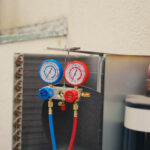 close-up-manifold-gauges-used-checking-air-conditioner-refrigerant-need-maintenance-protection-helmet-set-barometer-high-low-freon-levels-benchmarking-hvac-system-component